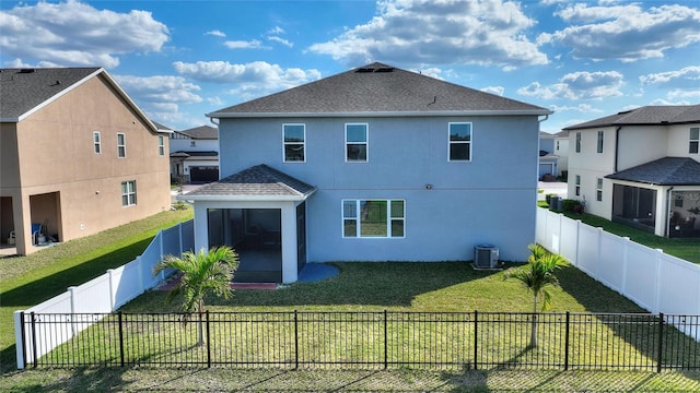 rear view of property featuring central air condition unit, stucco siding, a lawn, a fenced backyard, and roof with shingles