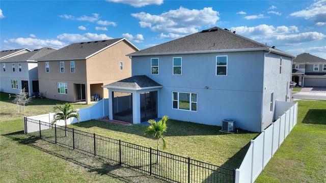 rear view of house featuring a yard, central air condition unit, a fenced backyard, and stucco siding