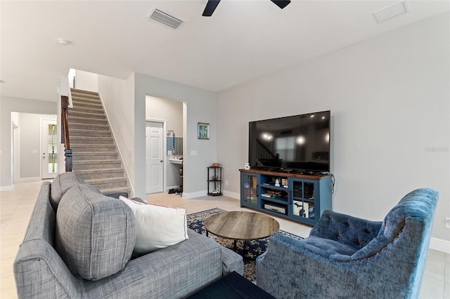 living area with light tile patterned flooring, visible vents, stairway, and a ceiling fan