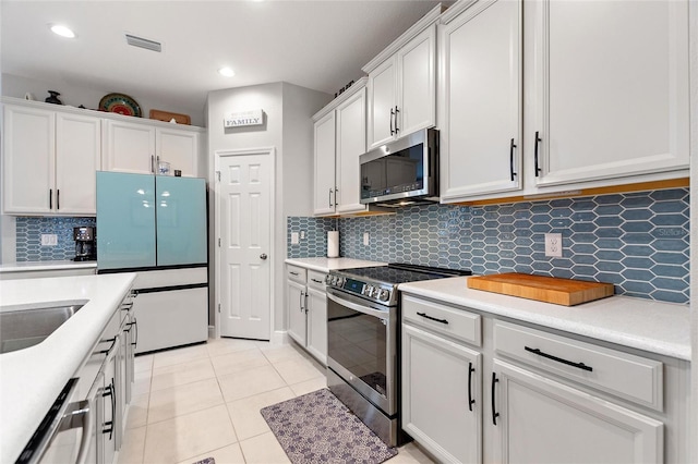 kitchen with light tile patterned floors, visible vents, appliances with stainless steel finishes, and white cabinetry