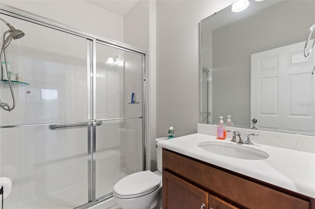 full bath featuring toilet, a stall shower, and vanity