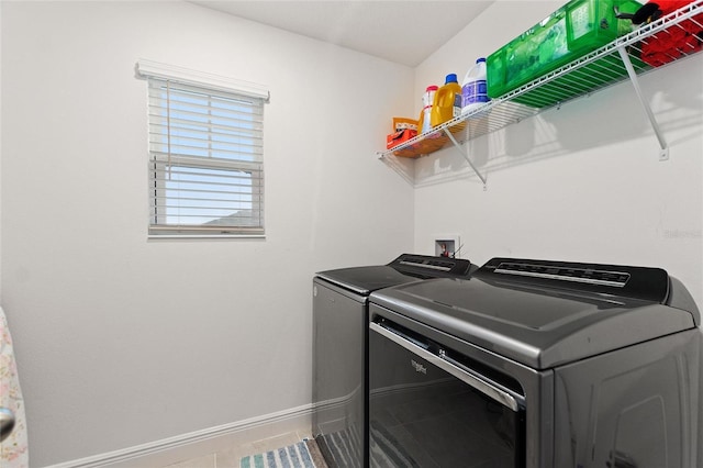 laundry room with baseboards, separate washer and dryer, laundry area, and tile patterned flooring