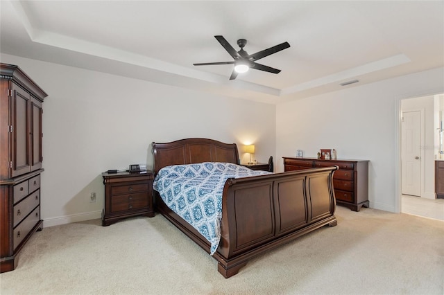 bedroom with visible vents, baseboards, a tray ceiling, ceiling fan, and light colored carpet