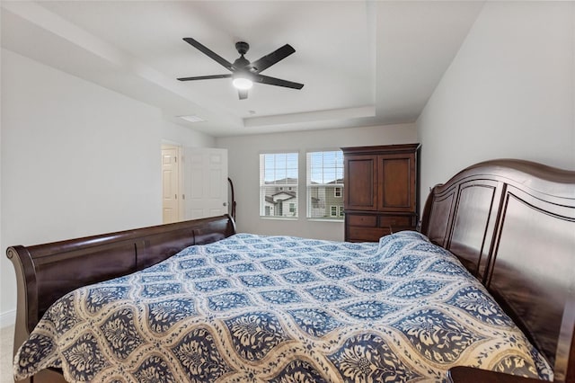 bedroom featuring a raised ceiling and a ceiling fan