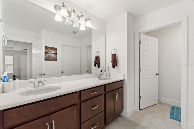 bathroom with tile patterned floors, double vanity, visible vents, and a sink