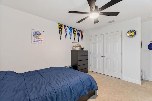 bedroom with visible vents, a ceiling fan, a closet, baseboards, and light colored carpet