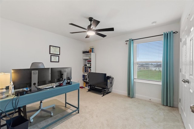 office space with light colored carpet, baseboards, and a ceiling fan