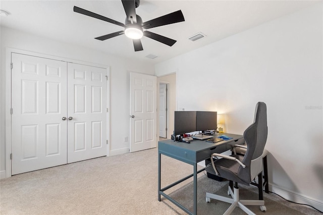 carpeted office space with baseboards, visible vents, and ceiling fan