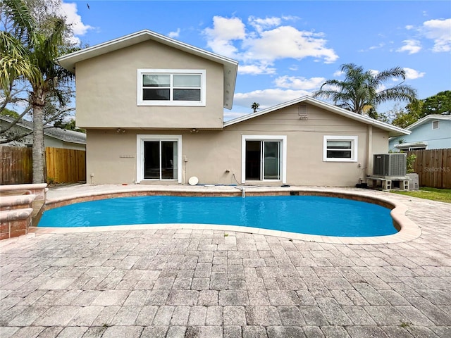 view of swimming pool with a fenced in pool, a patio, central AC unit, and fence