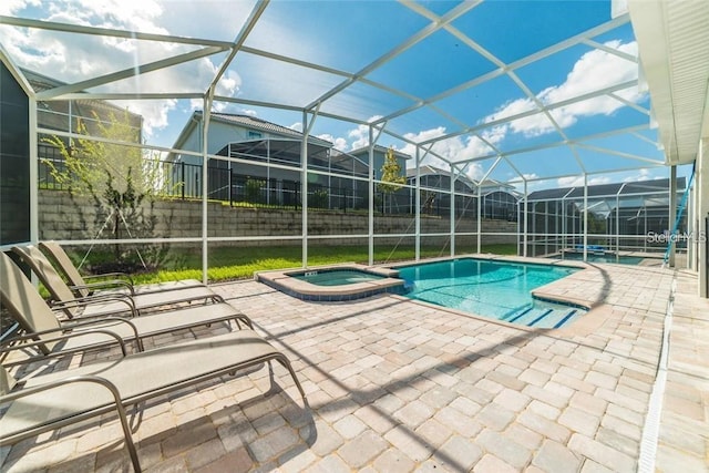 view of swimming pool with glass enclosure, a residential view, a pool with connected hot tub, and a patio area