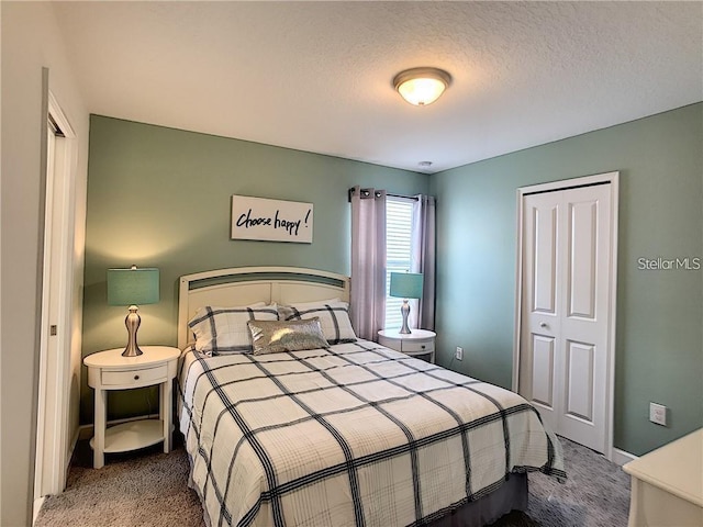 carpeted bedroom with a closet and a textured ceiling