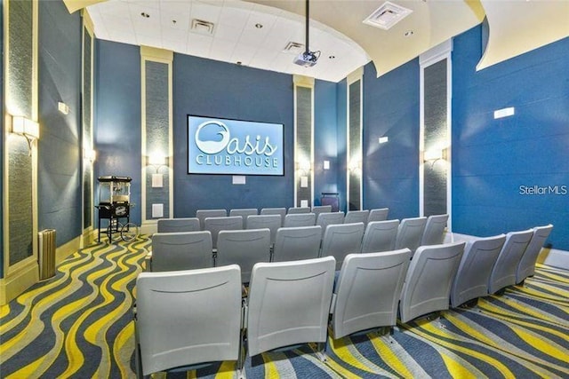 carpeted home theater room featuring visible vents