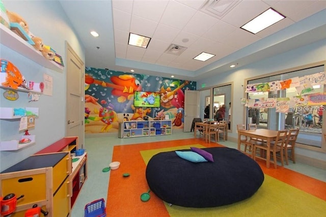 rec room with a raised ceiling, recessed lighting, and visible vents