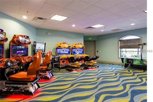 recreation room featuring carpet flooring, baseboards, visible vents, and a drop ceiling