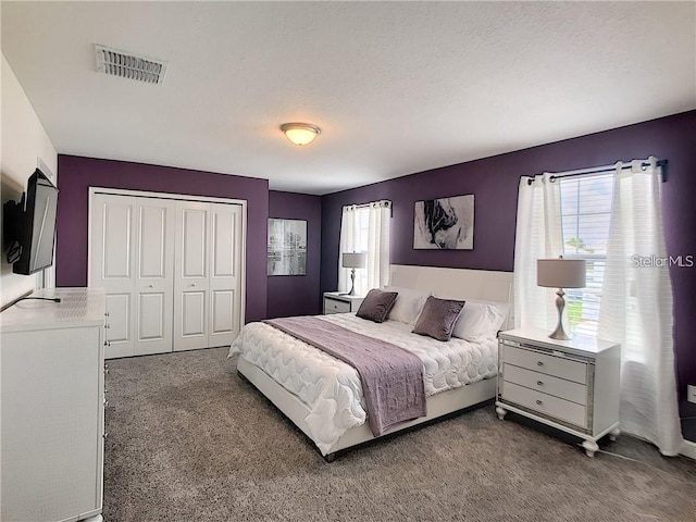 carpeted bedroom featuring visible vents, a closet, and a textured ceiling