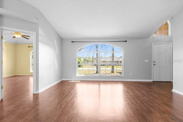 unfurnished room featuring a textured ceiling, wood finished floors, baseboards, and ceiling fan