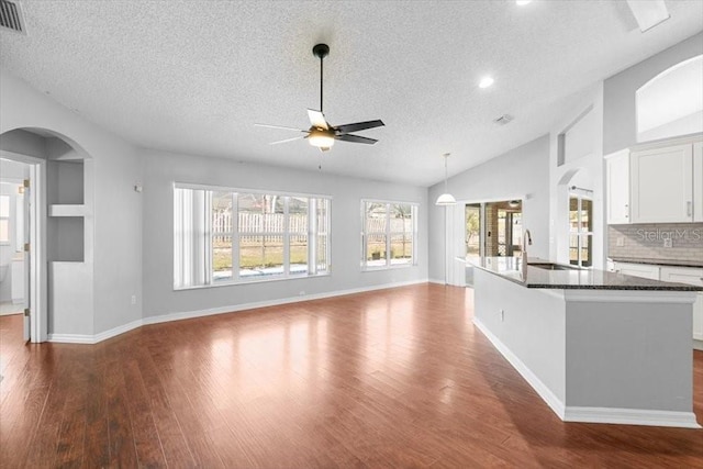 interior space featuring a sink, ceiling fan, dark wood finished floors, and vaulted ceiling