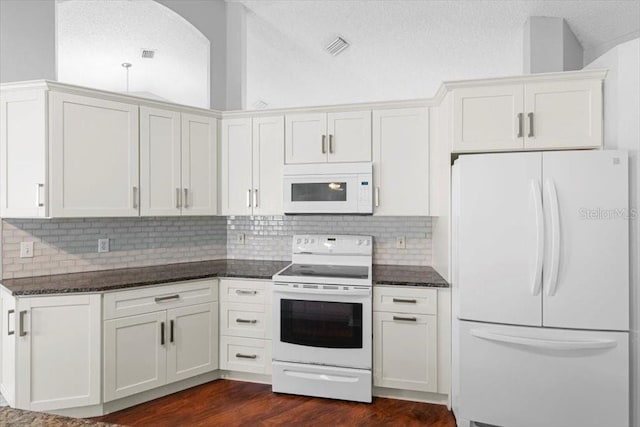 kitchen with dark wood finished floors, white appliances, decorative backsplash, and a textured ceiling