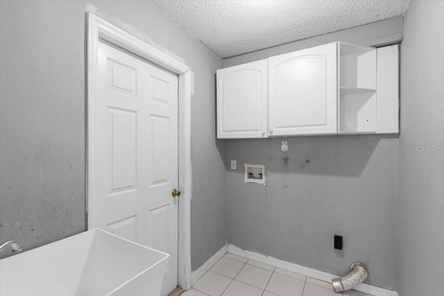 washroom with hookup for a washing machine, light tile patterned flooring, cabinet space, hookup for an electric dryer, and a textured ceiling