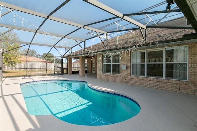 view of swimming pool featuring a fenced in pool, fence, a lanai, and a patio area