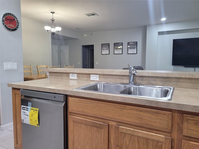 kitchen featuring visible vents, dishwasher, pendant lighting, brown cabinets, and a sink