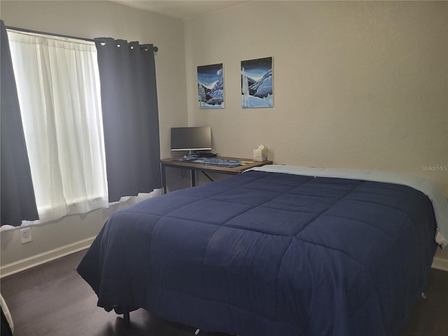 bedroom with wood finished floors and baseboards