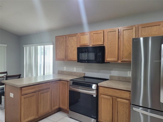 kitchen featuring appliances with stainless steel finishes, a peninsula, light tile patterned flooring, and light countertops