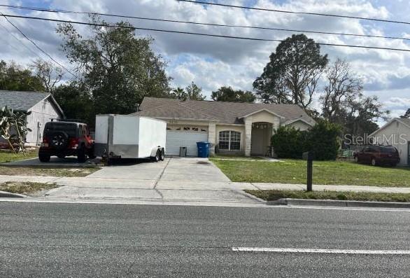 view of front of house with a garage, a front yard, and driveway