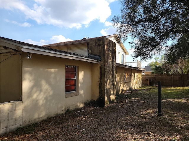 view of property exterior featuring fence and stucco siding