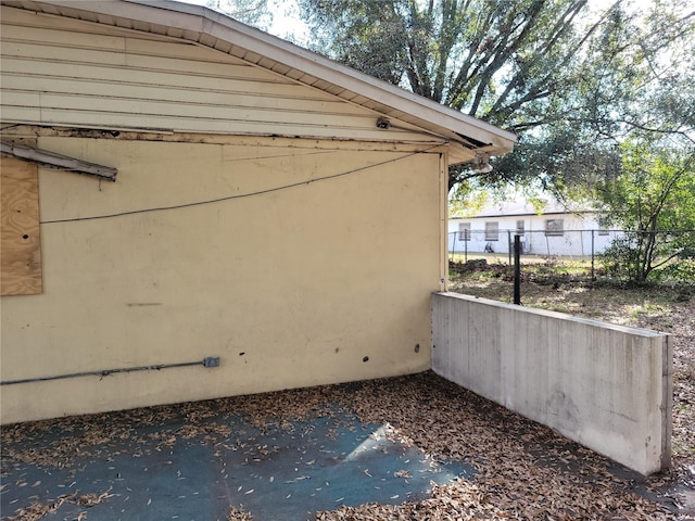 view of side of home featuring fence