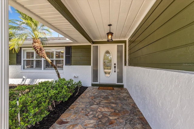 doorway to property featuring stucco siding