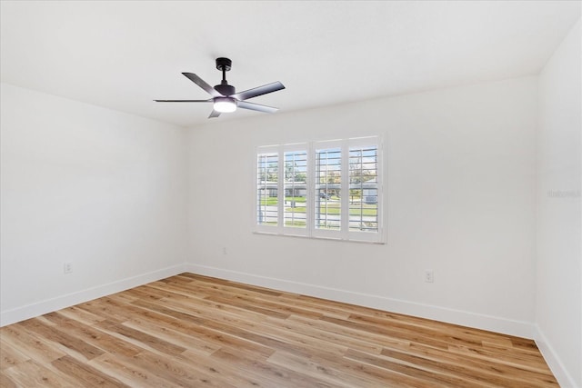 empty room featuring a ceiling fan, light wood-type flooring, and baseboards