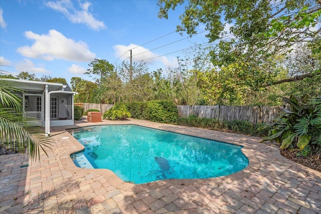 view of swimming pool featuring a fenced in pool, a patio, a fenced backyard, and a sunroom