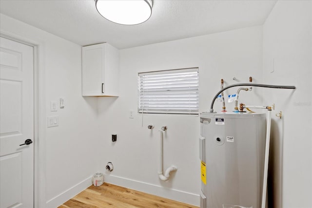 laundry room featuring baseboards, hookup for an electric dryer, cabinet space, water heater, and light wood-style floors