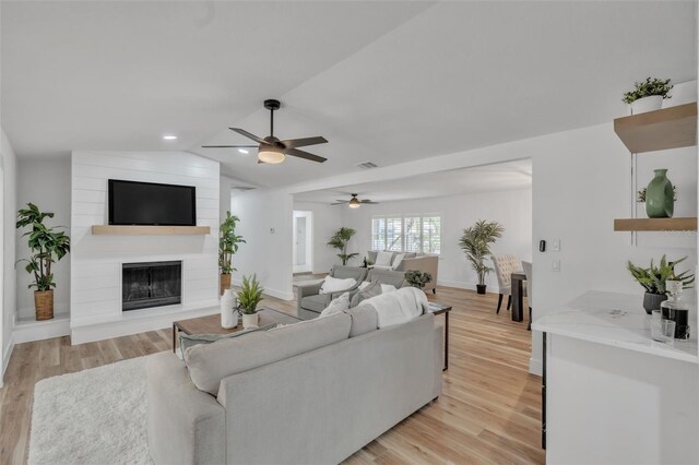 116 E Cottesmore Cir, Longwood, FL 32779 - living area with a large fireplace, light wood-style flooring, vaulted ceiling, and a ceiling fan