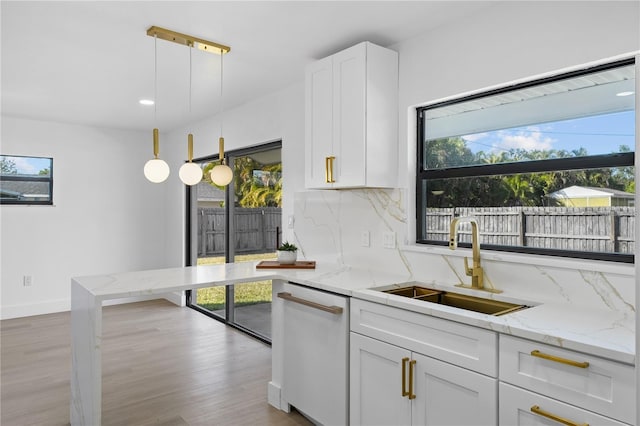 607 Dunblane Dr, Winter Park, FL 32792 - kitchen featuring tasteful backsplash, light stone countertops, dishwasher, white cabinetry, and a sink
