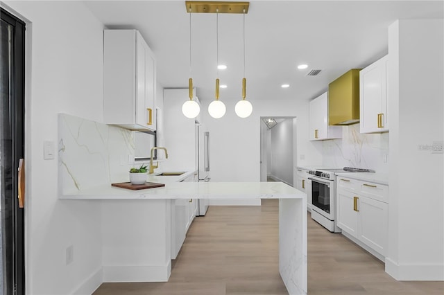 607 Dunblane Dr, Winter Park, FL 32792 - kitchen featuring white electric stove, a peninsula, a sink, white cabinets, and wall chimney range hood