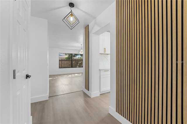 607 Dunblane Dr, Winter Park, FL 32792 - hall featuring a notable chandelier, light wood-style flooring, and baseboards