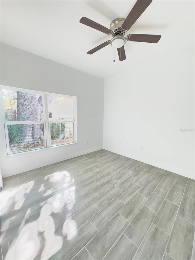 unfurnished room featuring baseboards, plenty of natural light, and ceiling fan