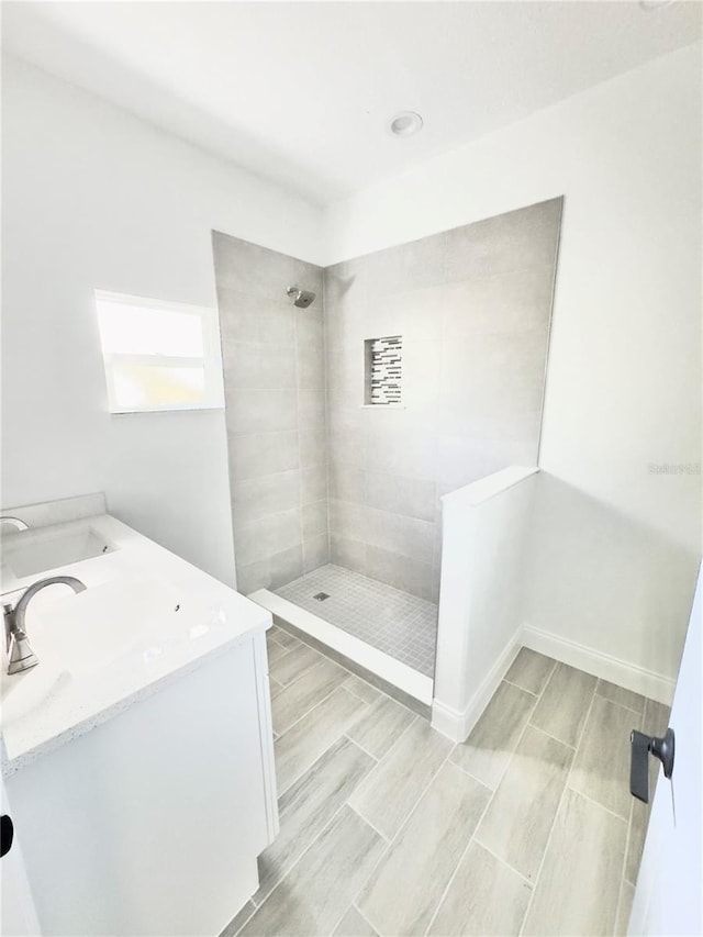 bathroom featuring vanity, wood tiled floor, and a tile shower