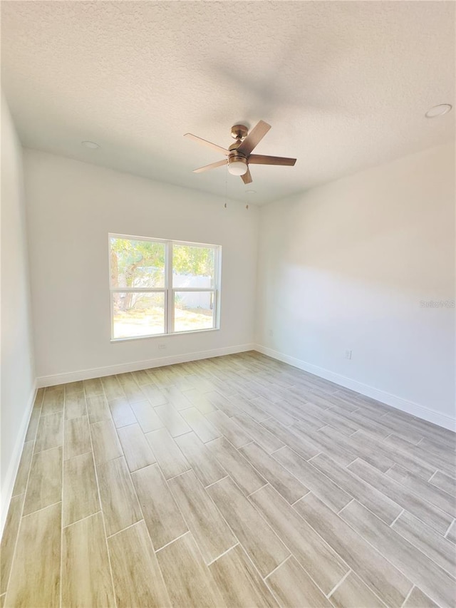 unfurnished room with light wood-style flooring, baseboards, and ceiling fan