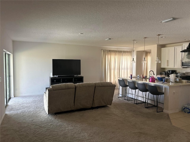 living area featuring visible vents, light colored carpet, and a textured ceiling