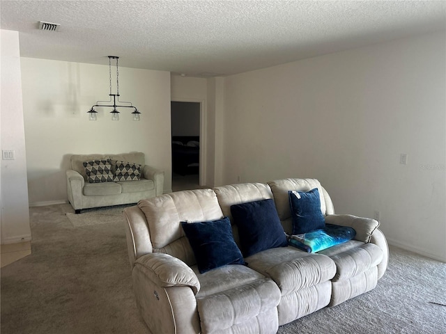 carpeted living room with visible vents, baseboards, and a textured ceiling