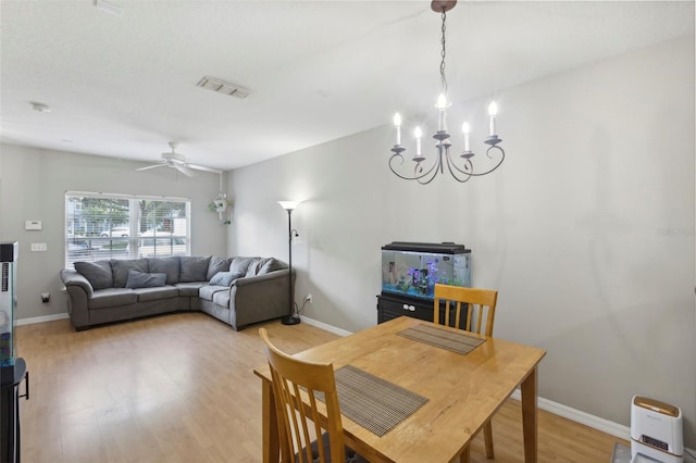 dining area featuring visible vents, baseboards, ceiling fan with notable chandelier, and light wood finished floors