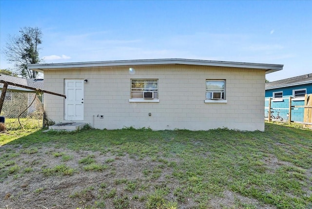 back of property featuring a lawn and fence