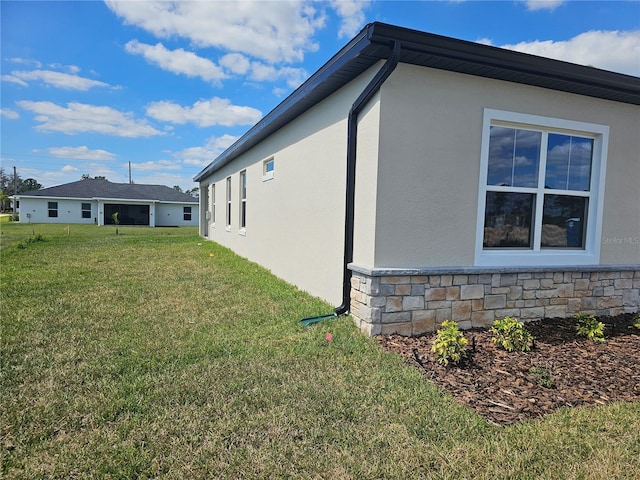 view of side of home featuring stone siding, stucco siding, and a yard