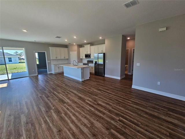 kitchen featuring visible vents, dark wood-type flooring, a sink, open floor plan, and appliances with stainless steel finishes