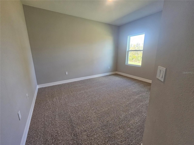 spare room featuring baseboards and carpet floors