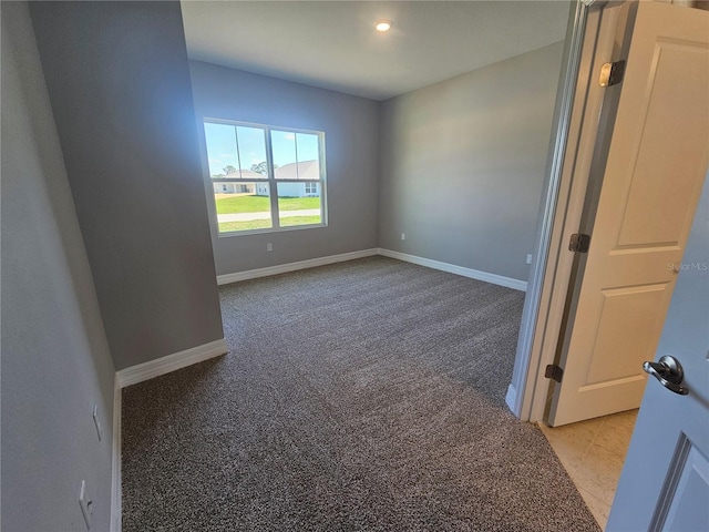 spare room with recessed lighting, light colored carpet, and baseboards