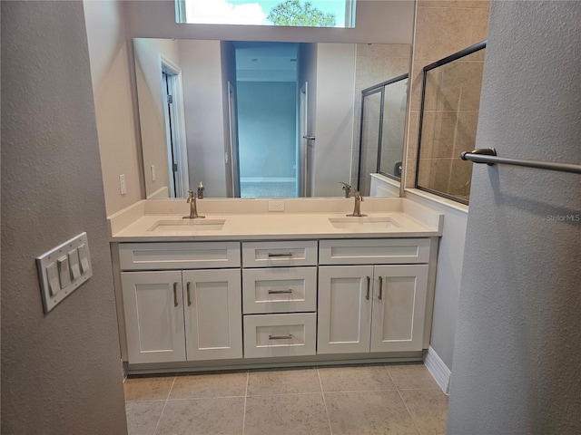 bathroom featuring double vanity, tile patterned flooring, a stall shower, and a sink